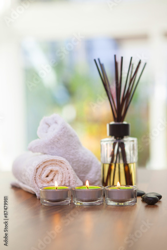 Spa towels, candles, hot stones and scent sticks shot fron on on a wooden background