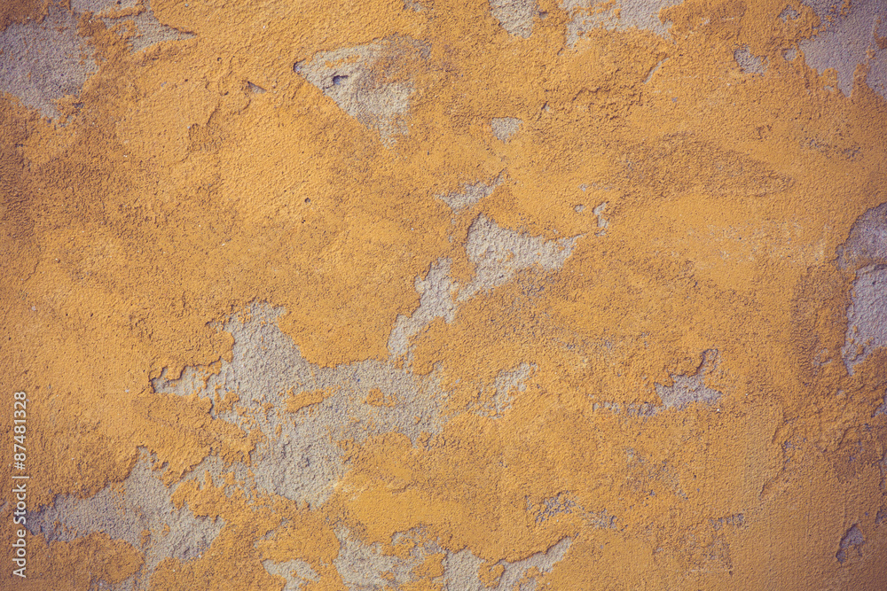 Texture of old rustic wall covered with yellow stucco vintage co