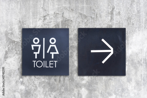 Unisex restroom or Toilet and arrow sign on  concrete wall style