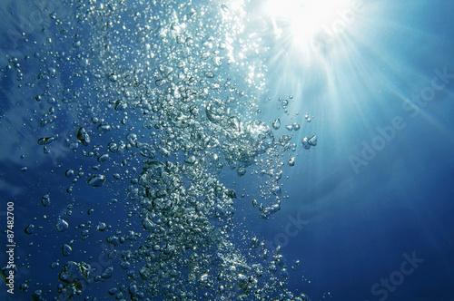 Underwater bubbles rising to surface with sunlight