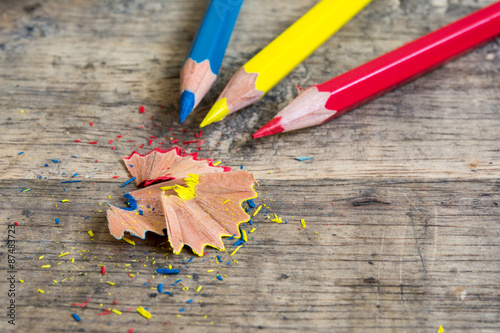 Sharpener and pencil shaves on wood with primary color pencils  photo