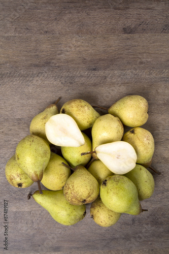 Some pears in a basket over a wooden surface seen from above