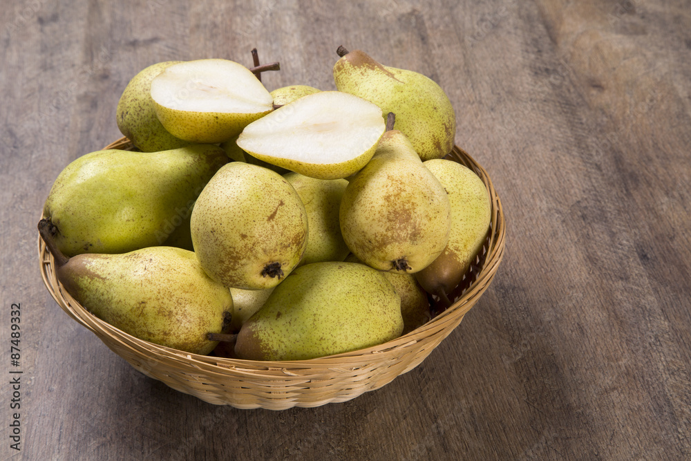 Some pears in a basket over a wooden surface seen from above Some pears in a basket over a wooden surface seen from above