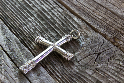 Silver christian cross on wooden background