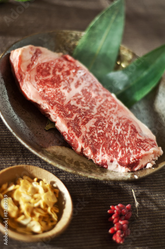 Raw fresh marbled meat Black Angus Steak with garlic chips. Japanese Kobe veal.