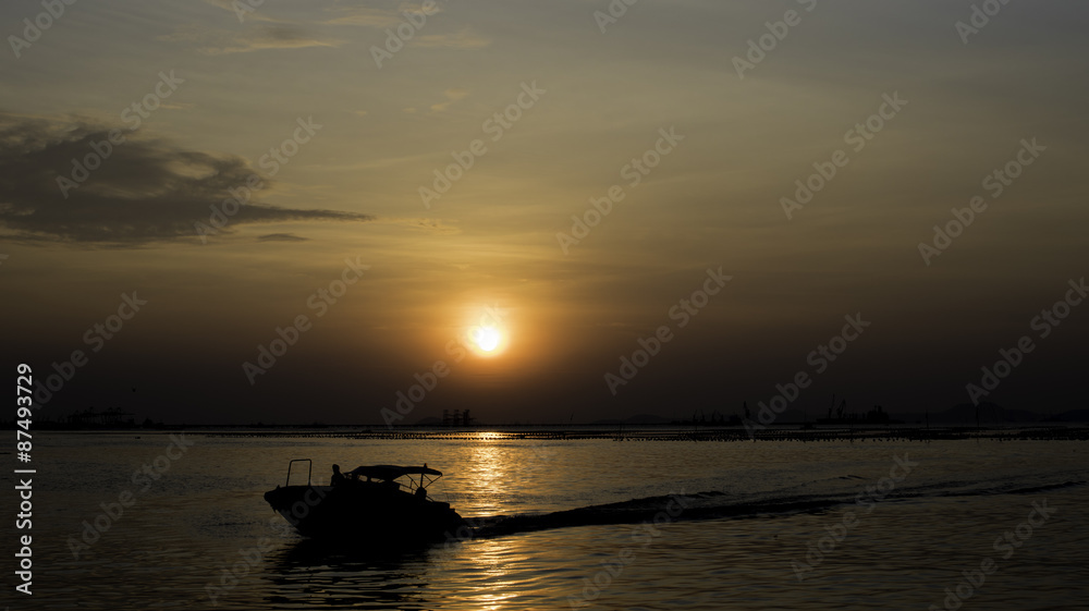 Speed boat silhouette in sea with sunset sky