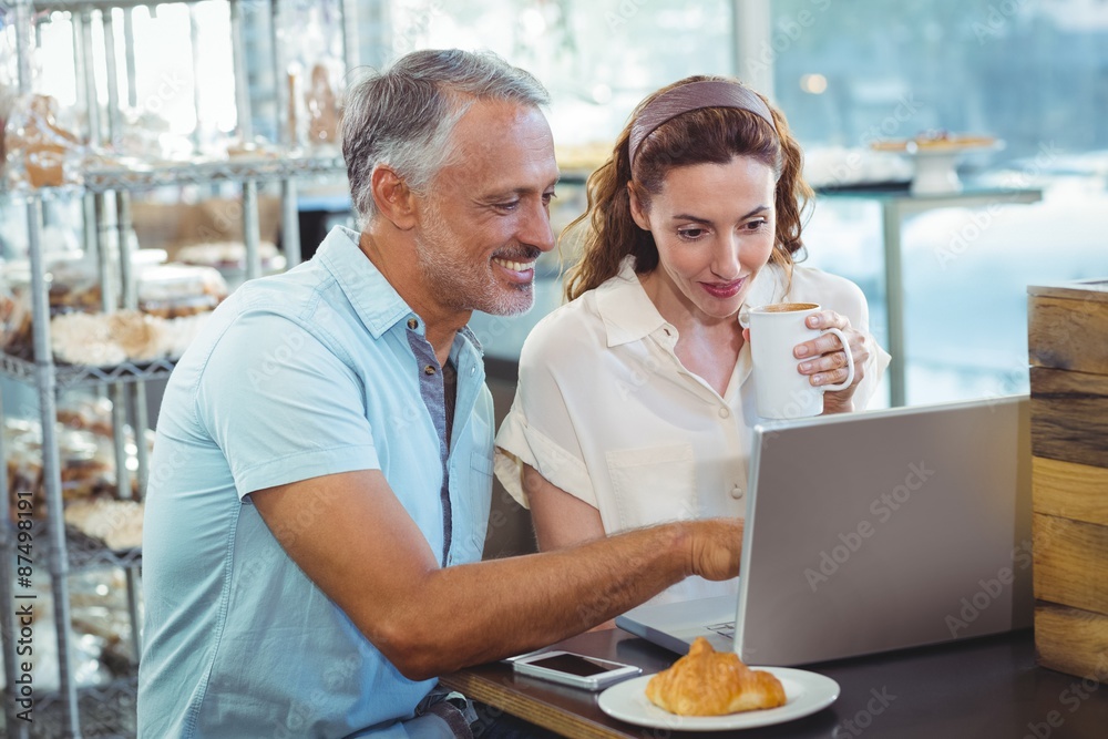 Happy couple pointing something on laptop Happy couple pointing something on laptop