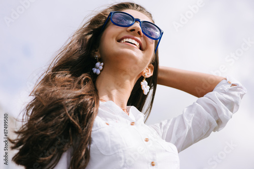 Attractive happy woman in sunglasses enjoying freedom outdoors.