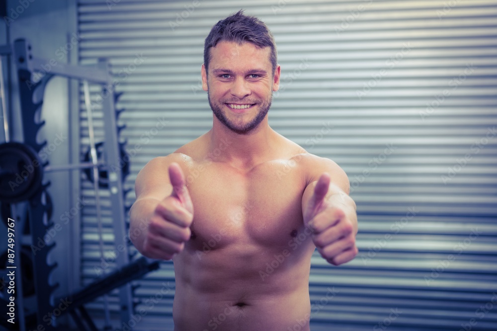 © WavebreakmediaMicro - Portrait of smiling muscular man looking at camera with thumb up