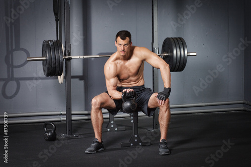 Man sitting and holding a kettlebell - crossfit