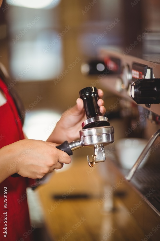Close up of a barista pressing coffee