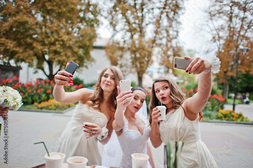 Young bridesmaid with bride doing selfie