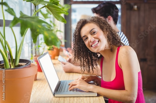 Smiling woman typing on a laptop