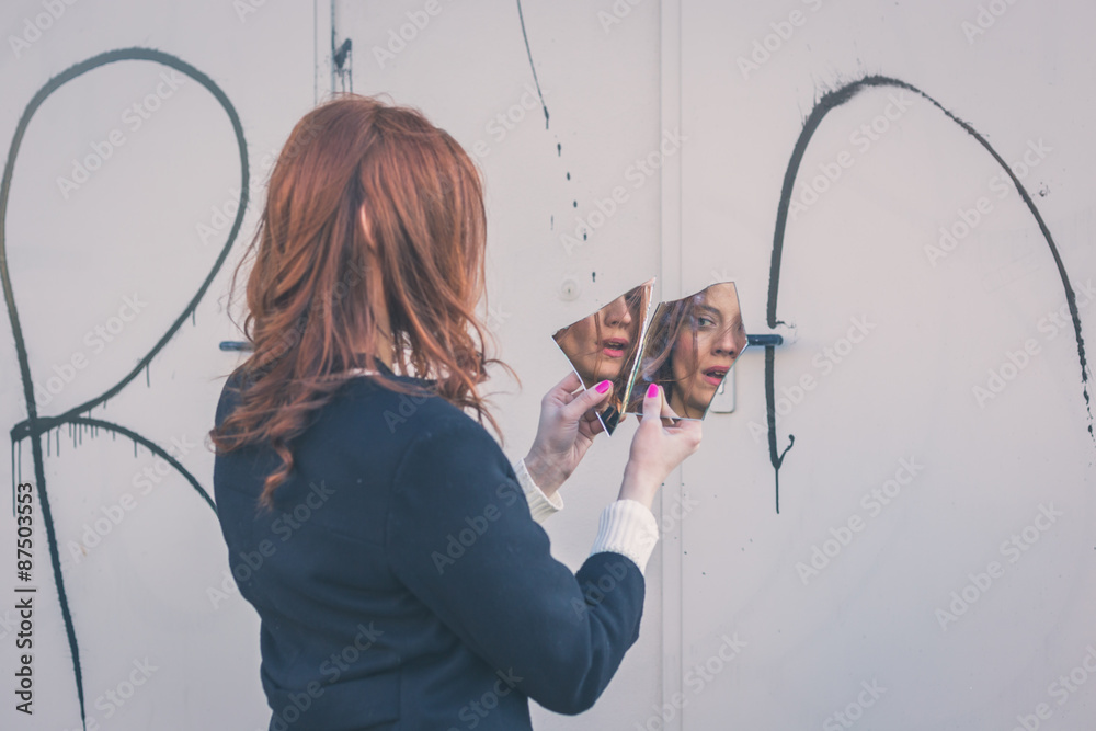 Beautiful girl looking at herself in a mirror Beautiful girl looking at herself in a mirror