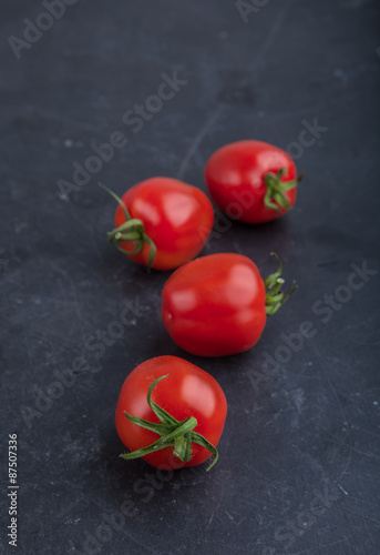 Ripe red tomatoes on black table