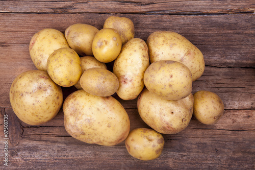 Potatoes bunch shot cropped on a wooden background from above 