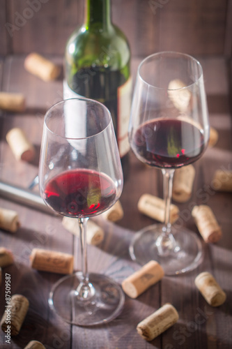 Red wine glasses, bottle and corks