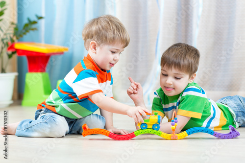 children playing rail road toy in nursery