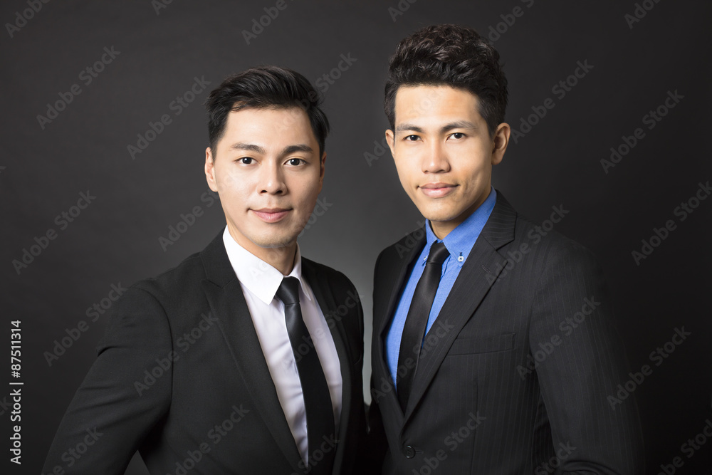 two young businessman with black background two young businessman with black background