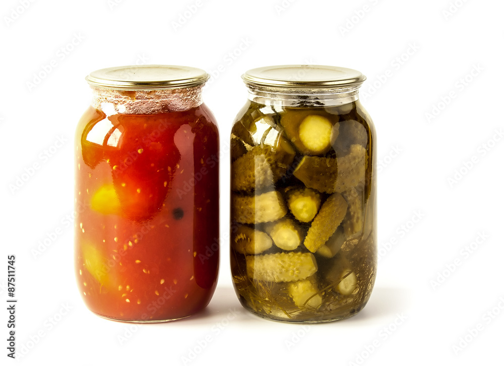 Salted cucumbers and tomatoes in glass jars isolated on white Salted cucumbers and tomatoes in glass jars isolated on white