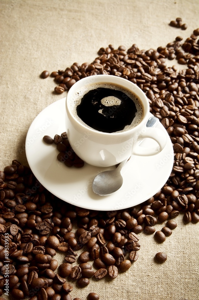Wave made of coffee beans with cup of frothy coffee Wave made of coffee beans with cup of frothy coffee