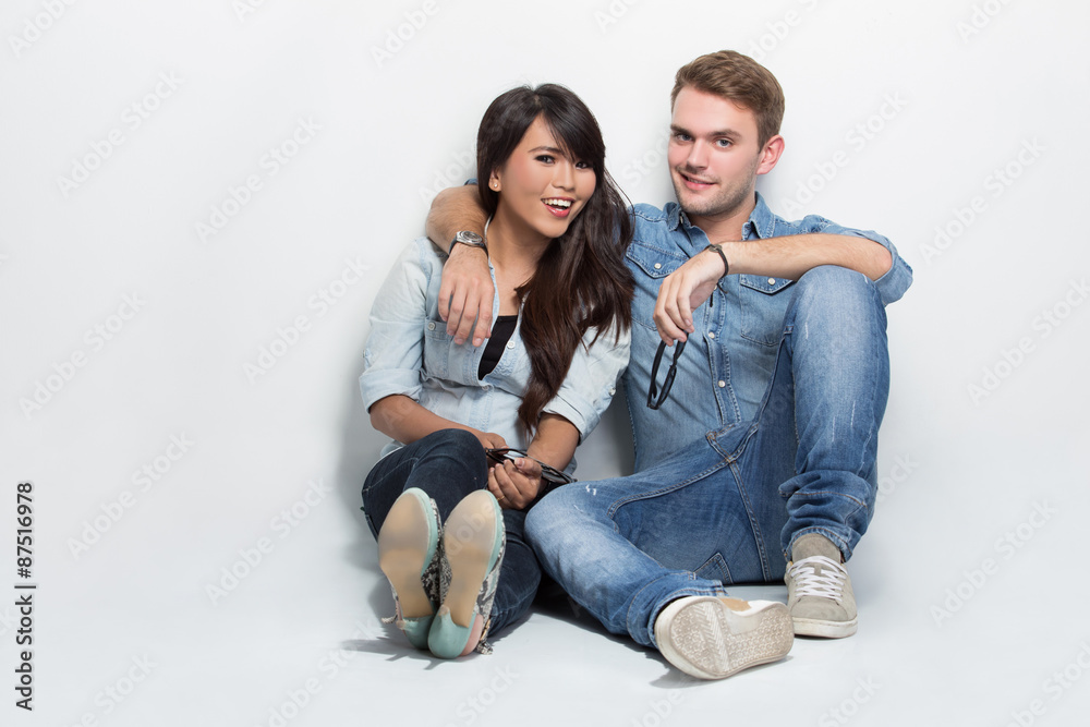 Mixed couple sitting on the floor. man embracing woman Mixed couple sitting on the floor. man embracing woman