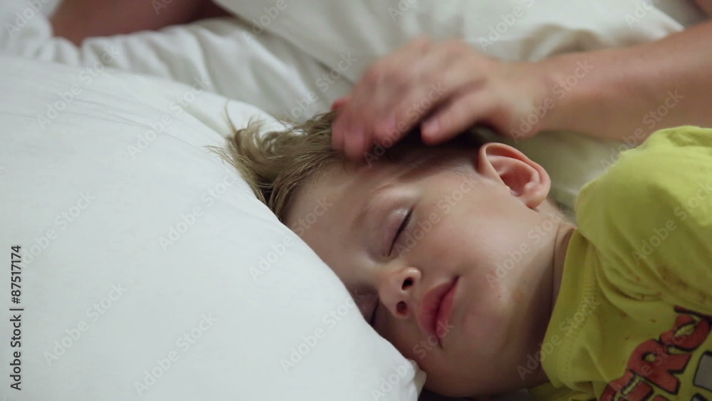 The little boy sleeps, his mother gently strokes his head
The little boy sleeps, his mother gently strokes his head