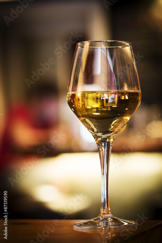 glass of white wine on bar counter