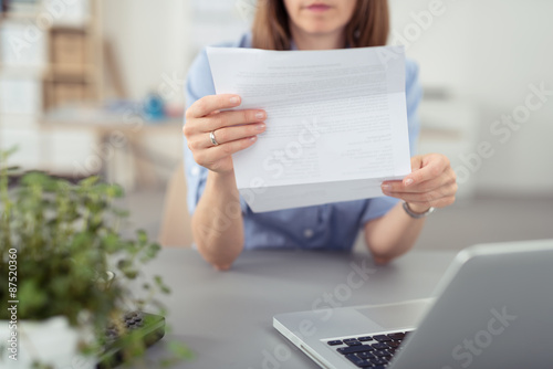 Photos frau sitzt am schreibtisch und liest einen brief