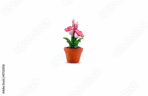 Plastic fake pink flower with brown pot toy isolated on white background