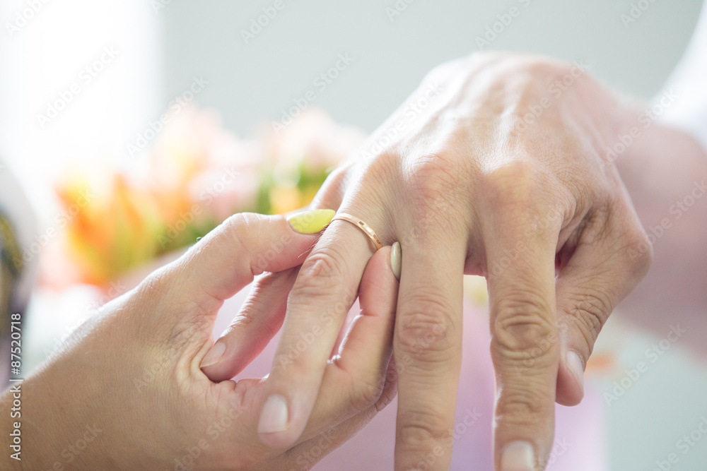 Naklejka premium bride dresses gold wedding ring on a finger to the groom
