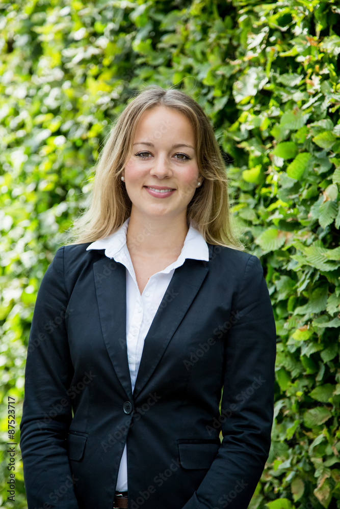 junge blonde Geschäftsfrau steht vor einem grünen Hintergrund junge blonde Geschäftsfrau steht vor einem grünen Hintergrund