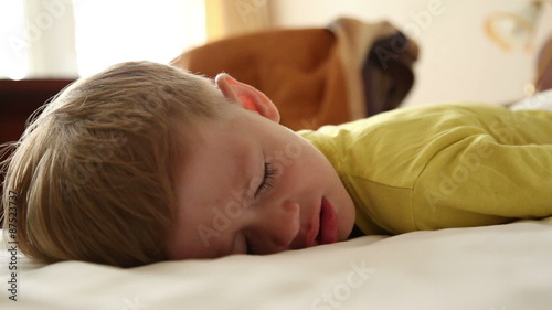 Little boy trying to wake up, he removes diaper and gets out of bed
