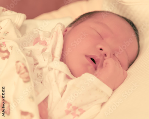 Asian baby female sleep on bed focused on her face creamy tone
