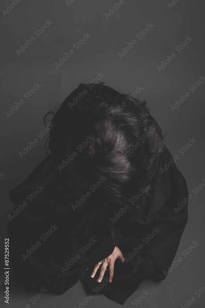 Vampire, gothic dark woman with large black cloth on gray backgr Vampire, gothic dark woman with large black cloth on gray backgr