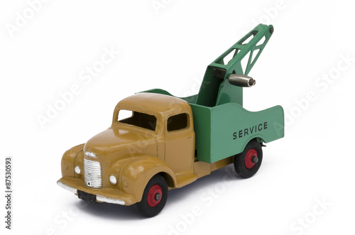 Vintage green and brown toy towing truck. Isolated against a white background.