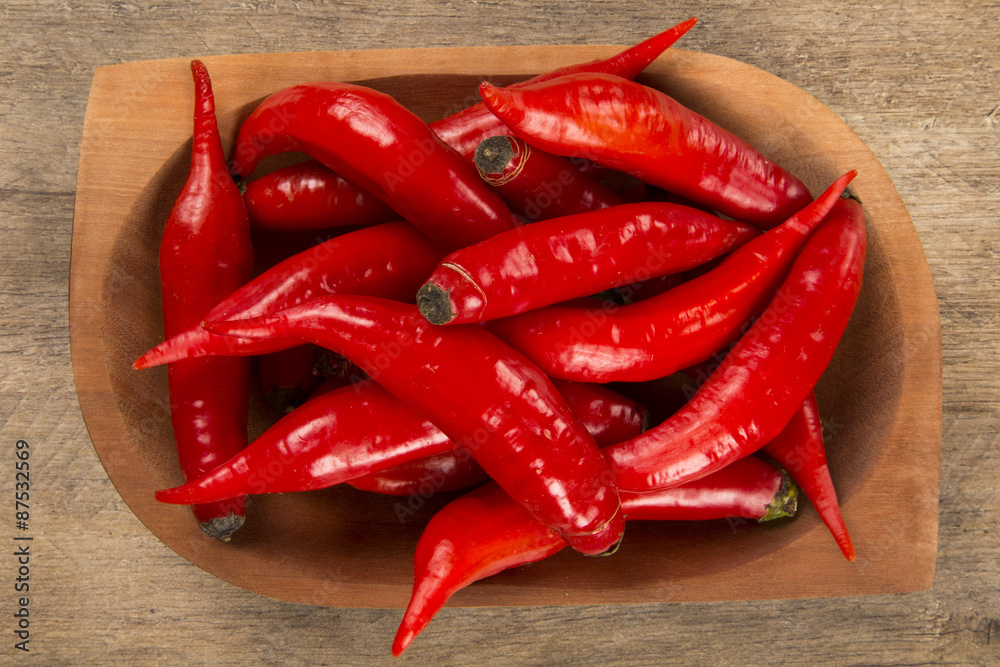 Group of fresh red hot peppers on a wooden table