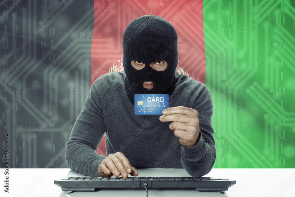 Dark-skinned hacker with flag on background holding credit card - Afghanistan Dark-skinned hacker with flag on background holding credit card - Afghanistan