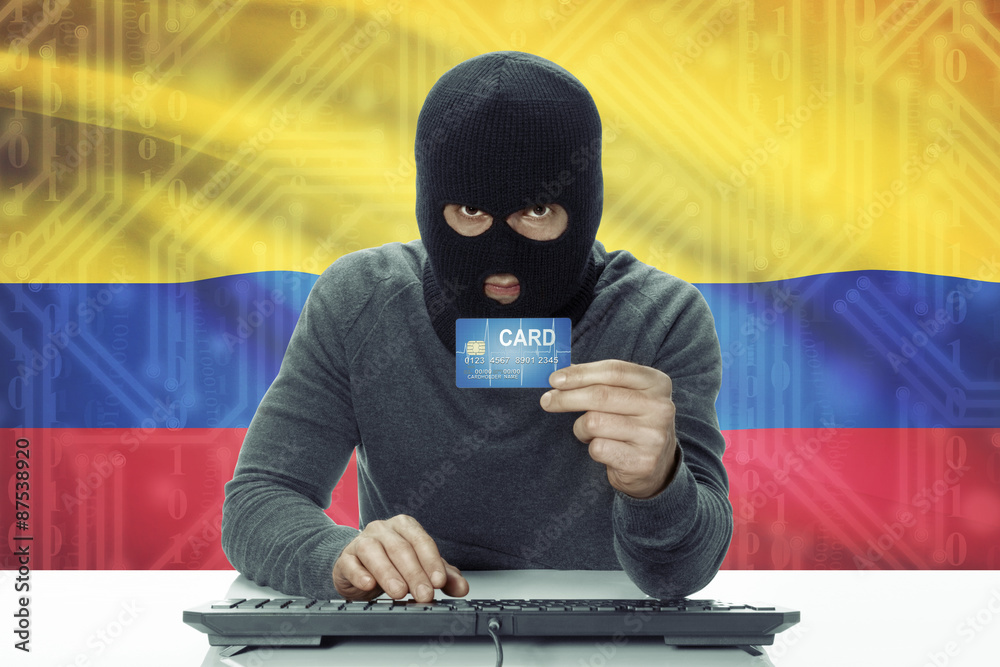 Dark-skinned hacker with flag on background holding credit card - Colombia Dark-skinned hacker with flag on background holding credit card - Colombia