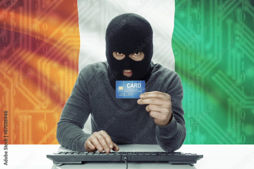Dark-skinned hacker with flag on background holding credit card - Ivory Coast Dark-skinned hacker with flag on background holding credit card - Ivory Coast