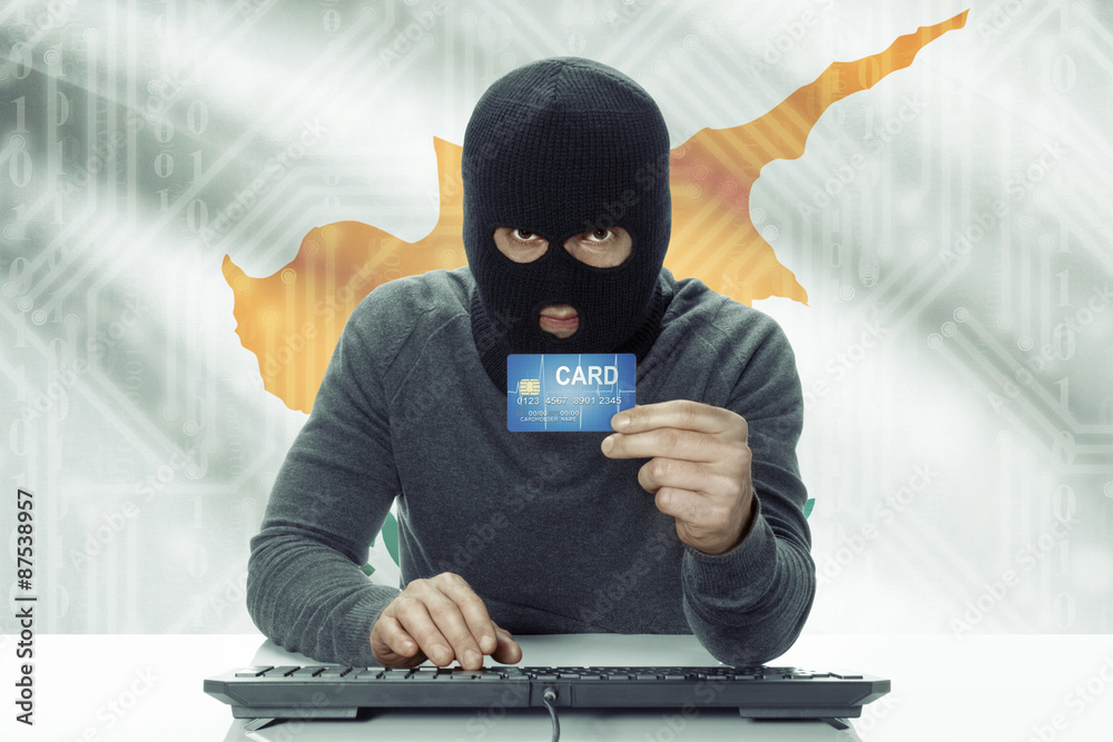 Dark-skinned hacker with flag on background holding credit card - Cyprus Dark-skinned hacker with flag on background holding credit card - Cyprus