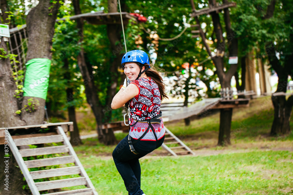 Adventure climbing high wire park - woman on course in mountain