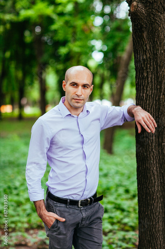 Fototapeta Naklejka Na Ścianę i Meble -  Portrait of a bald and brutal man in the park