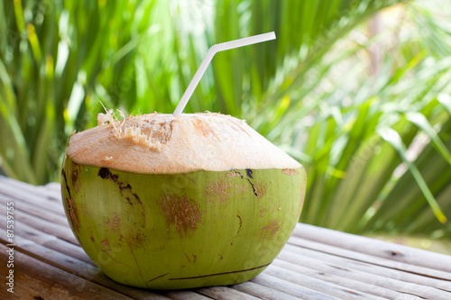 Fresh green coconut on palm tree background 