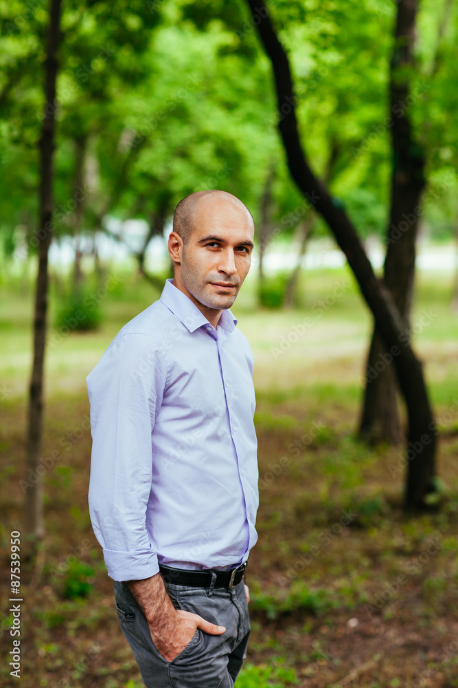 Portrait of a bald and brutal man in the park Portrait of a bald and brutal man in the park