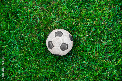 Old and classic Soccer ball or football ball on green field © irontrybex