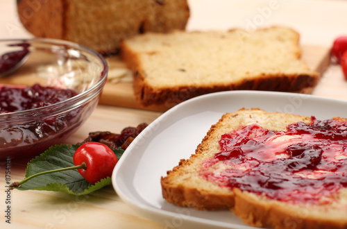Sweet bread  with raisins and almonds, butter and cherry jam