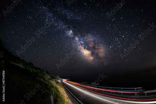 Fotobehang Light trails on the road with the milky way galaxy on the sky (horizontal)
