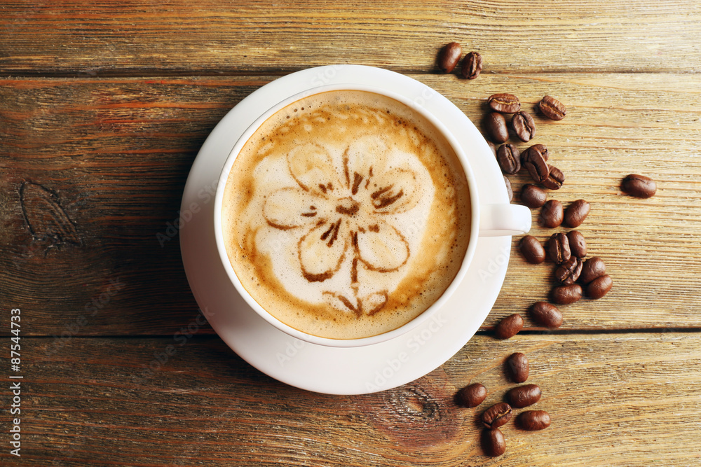 Cup of coffee latte art with grains on wooden background Cup of coffee latte art with grains on wooden background