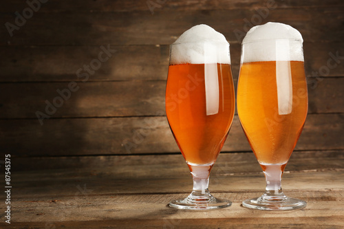 Glasses of beer on wooden background